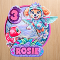 Personalised Skye dinosaur cake topper with the name Rosie and age 3 in pink, purple and glitter colours