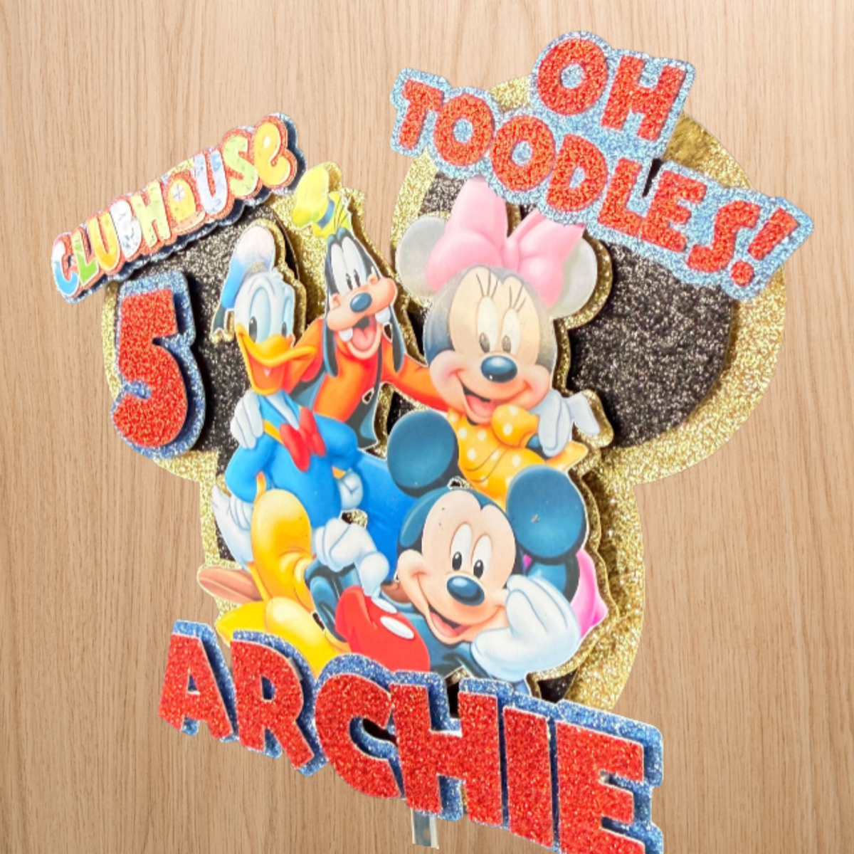 Close side view of the Mickey Mouse cake topper showing its handmade layered finish