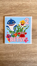 Baby Shark personalised 6x6 birthday card with blue and yellow sharks, colourful sea creatures, pink name Betsy and age 2
